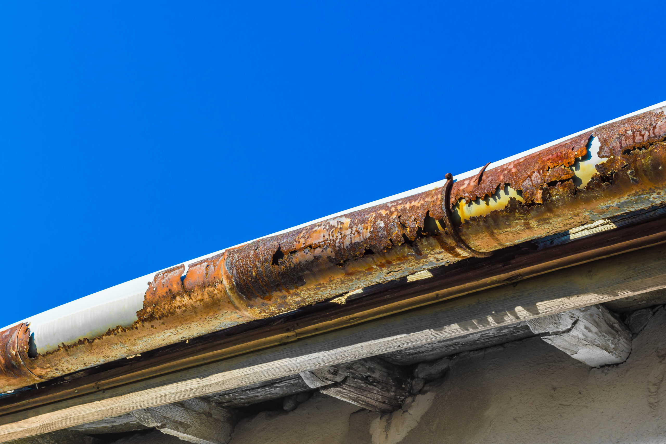 A broken gutter on the roof of a house